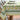 A tablecloth with a lemon and floral pattern, predominantly yellow and green, laid out on a table.